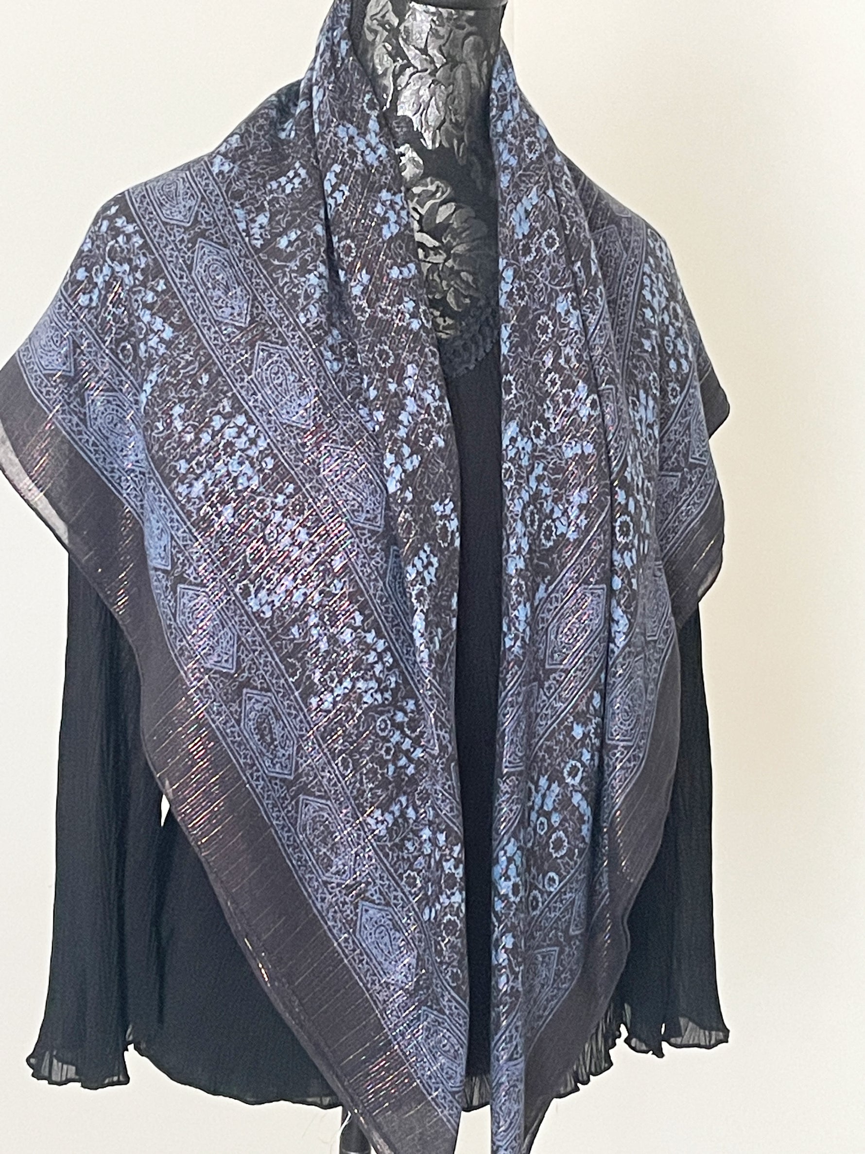 Charcoal printed scarf woven with sparkly lurex threads draped over a black top.