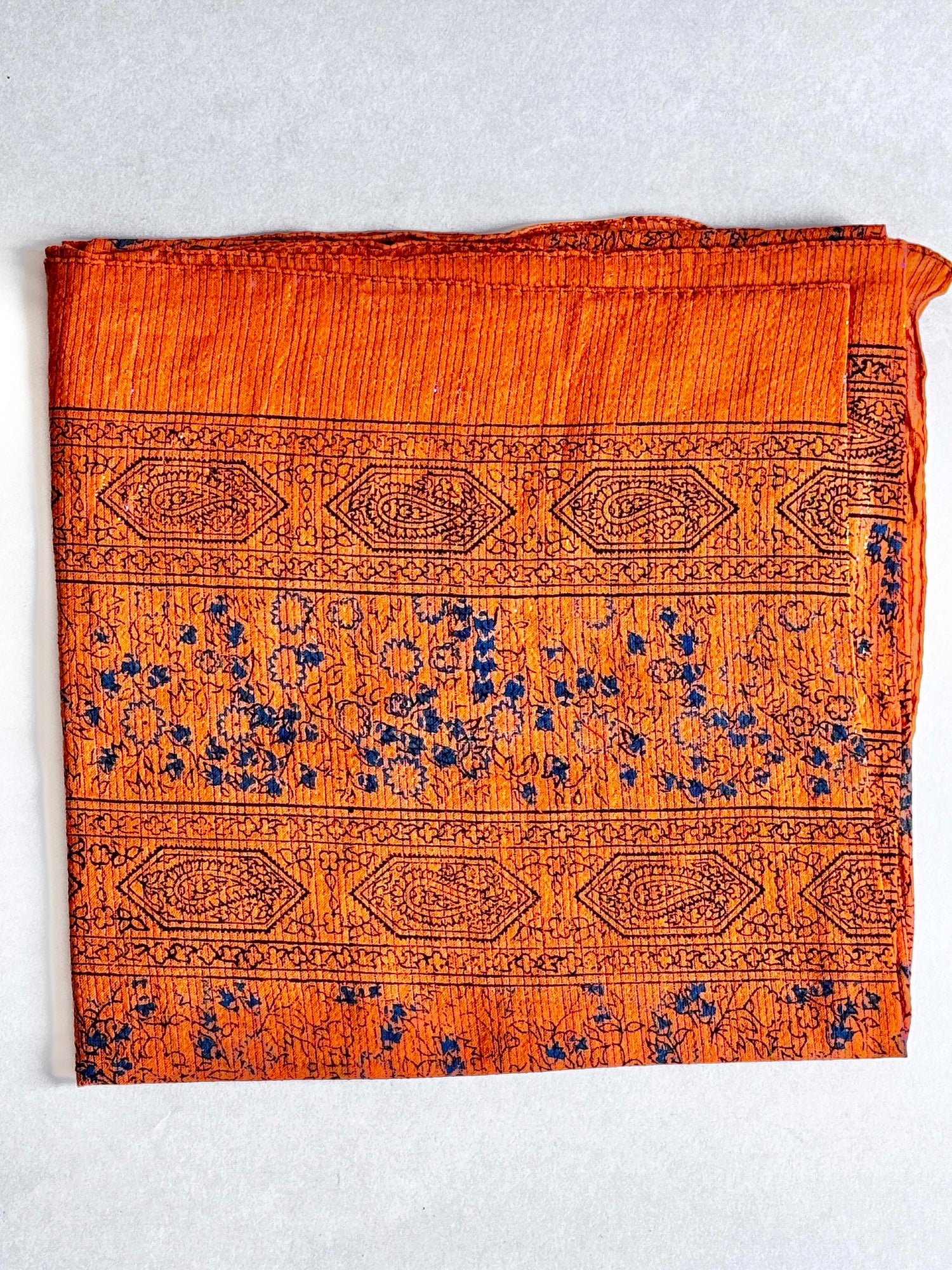Rusty orange coloured cotton square scarf woven with sparkly lurex threads and a d. blue printed pattern