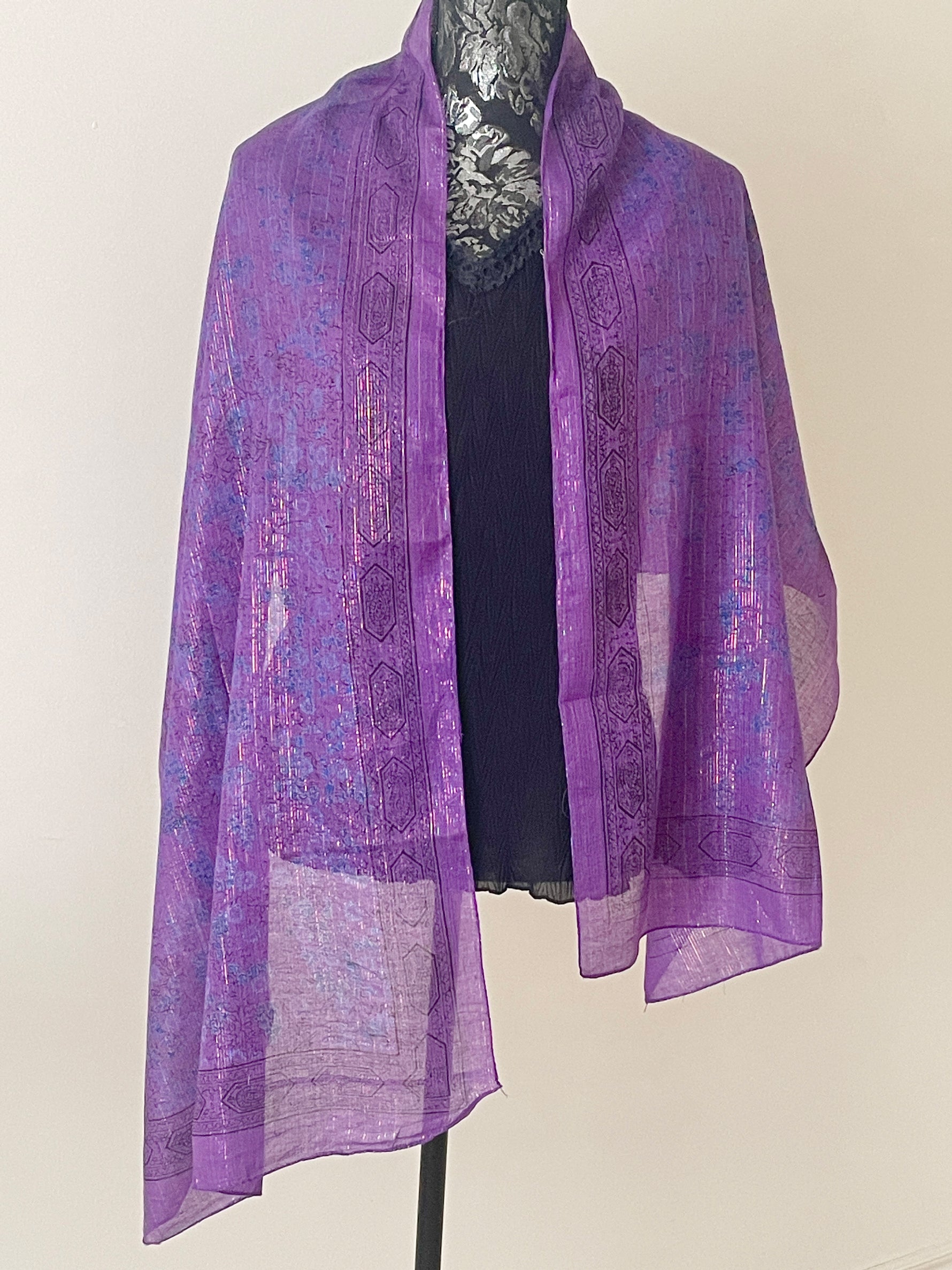 Dark purple printed scarf woven with sparkly lurex threads draped over a black top.